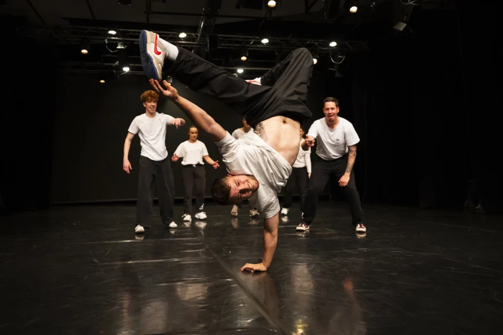 Breakdance plesalec Bast Arts izvaja freeze na eni roki med nastopom v Ljubljani.