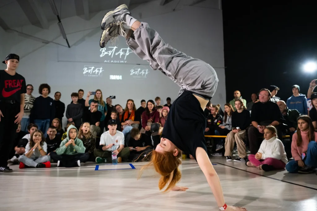 Bgirl v stoji na rokah med dvobojem na breaking tekmovanju Bast'a'move 4 v BastArts Academy
